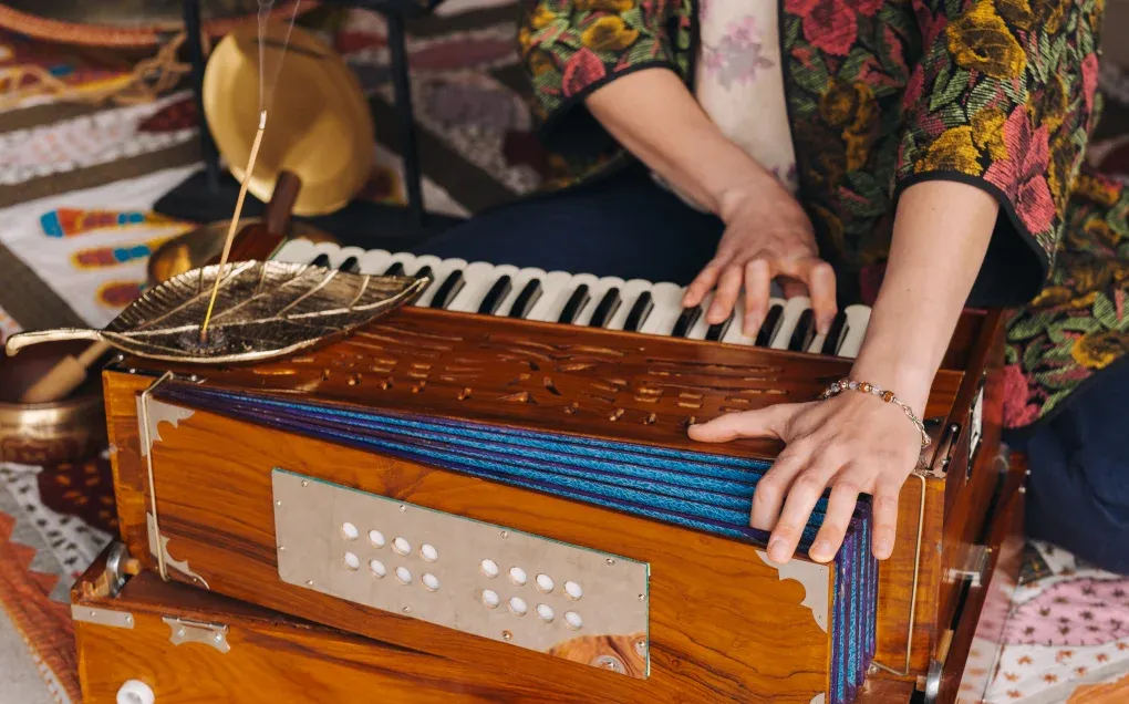 Hands playing a harmonium during an Indian classical music practice session
